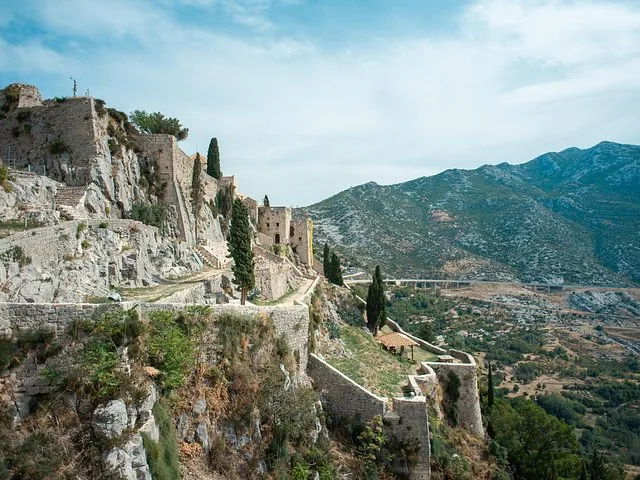 Stone walls and ramparts of Klis Fortress built into a hillside.